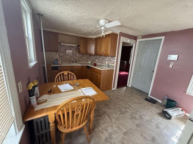64 Suffolk St, Worcester, MA 01604 - kitchen with ceiling fan, brown cabinetry, light countertops, backsplash, and a textured ceiling