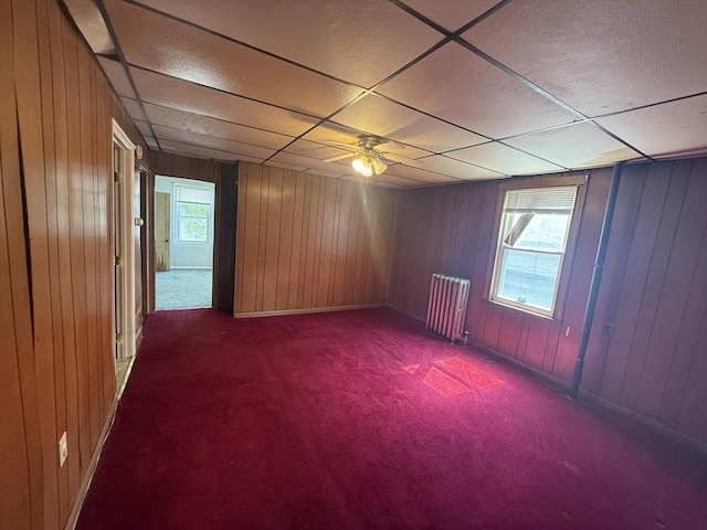 64 Suffolk St, Worcester, MA 01604 - carpeted empty room featuring radiator, a drop ceiling, wood walls, and ceiling fan