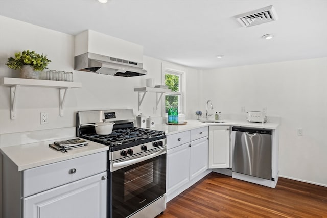 kitchen featuring white cabinets, sink, dark wood-type flooring, extractor fan, and appliances with stainless steel finishes