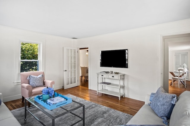 living room with french doors and dark wood-type flooring