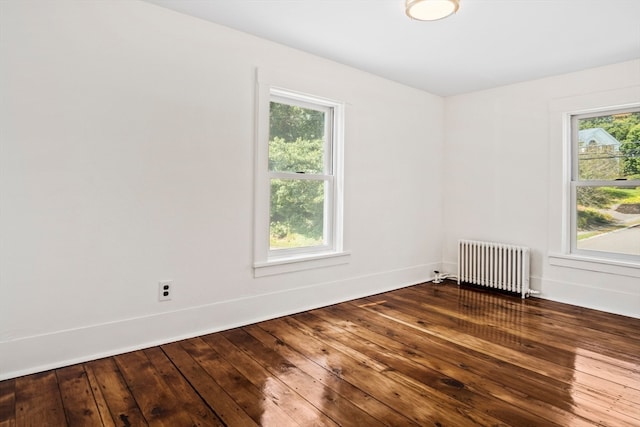 unfurnished room featuring wood-type flooring and radiator