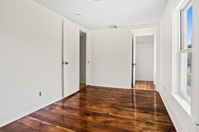 unfurnished bedroom with a closet and dark hardwood / wood-style floors