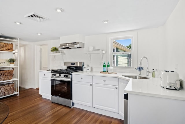 kitchen featuring sink, stainless steel gas stove, dark wood-type flooring, white cabinetry, and range hood