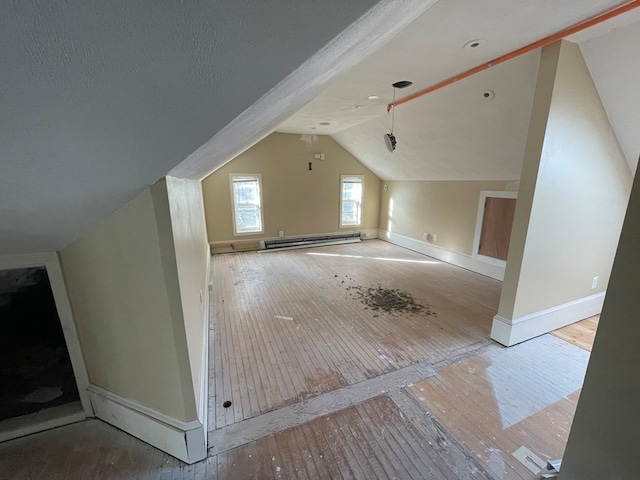 bonus room featuring vaulted ceiling, baseboard heating, and light hardwood / wood-style floors