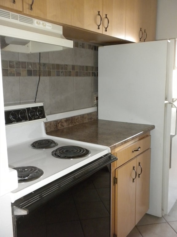 kitchen with white appliances and light tile patterned flooring