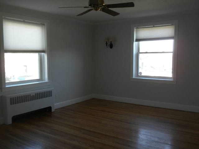 spare room with dark hardwood / wood-style floors, plenty of natural light, and radiator