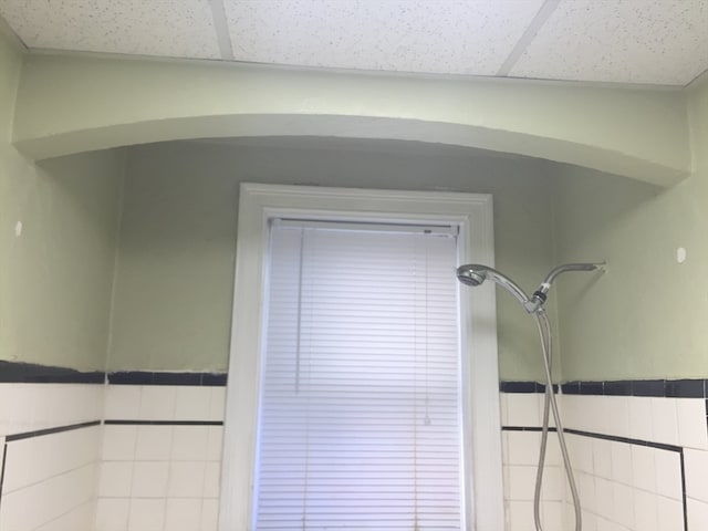 room details featuring a shower and a drop ceiling