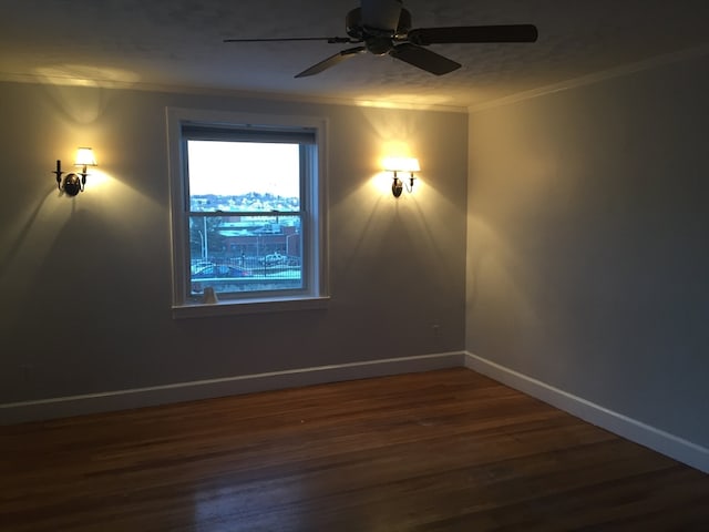 unfurnished room with ceiling fan, dark hardwood / wood-style flooring, and ornamental molding