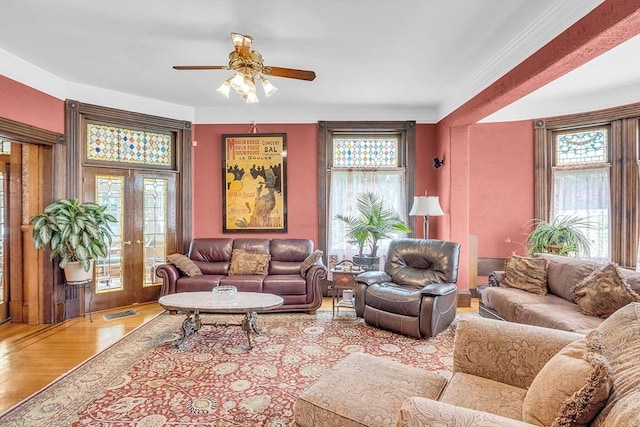 living room with crown molding, wood-type flooring, french doors, and ceiling fan