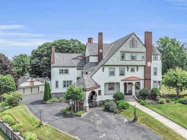 view of front of house with a garage, an outdoor structure, and a front lawn