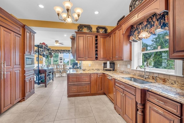 kitchen featuring light stone counters, sink, decorative light fixtures, and light tile patterned floors