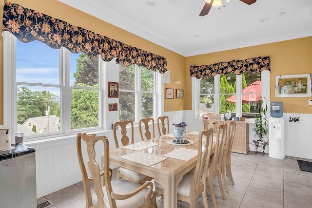 dining space featuring crown molding, light tile patterned floors, and ceiling fan