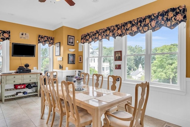 tiled dining area with crown molding and ceiling fan