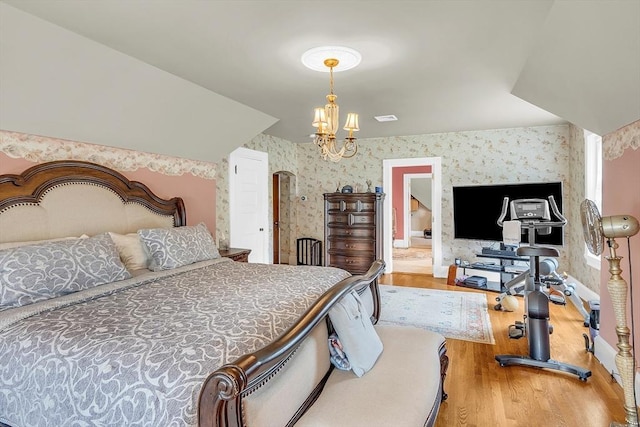 bedroom featuring an inviting chandelier and hardwood / wood-style floors