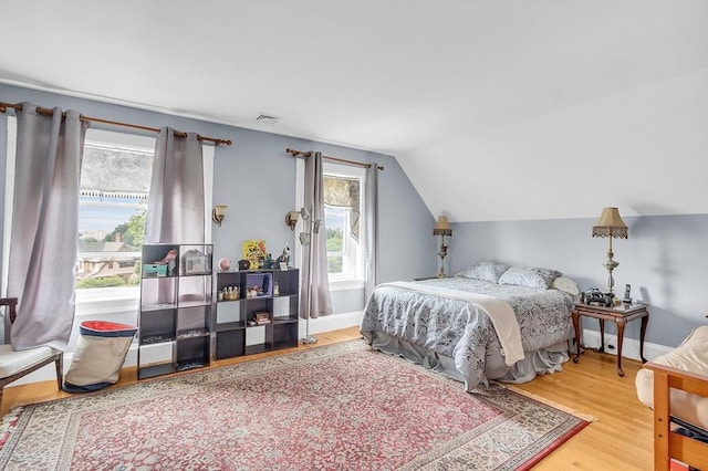 bedroom featuring vaulted ceiling and wood-type flooring