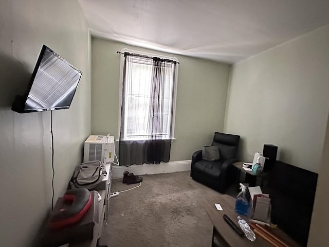 sitting room featuring carpet and a wall mounted air conditioner