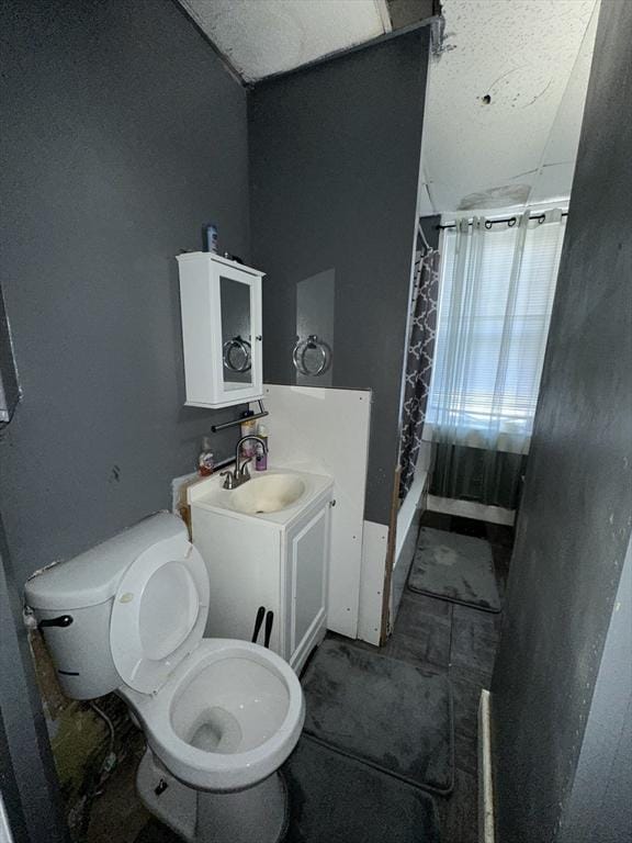 bathroom featuring vanity, walk in shower, and toilet