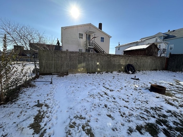 view of snow covered rear of property