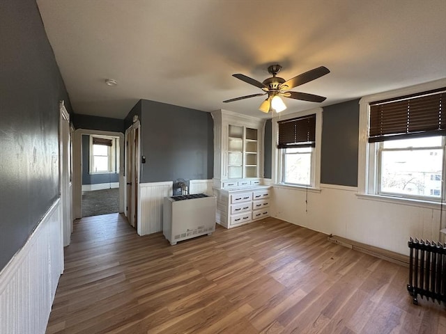 interior space featuring hardwood / wood-style floors, radiator heating unit, and ceiling fan