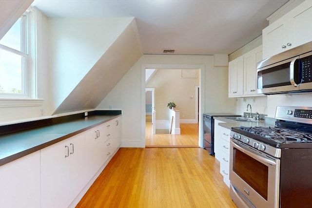 12 Bigelow Cir Unit 3, Boston, MA 02135 - kitchen with stainless steel appliances, dark countertops, white cabinets, and light wood-style flooring