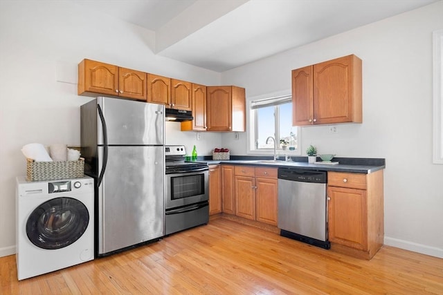 kitchen with washer / clothes dryer, sink, light hardwood / wood-style flooring, and appliances with stainless steel finishes