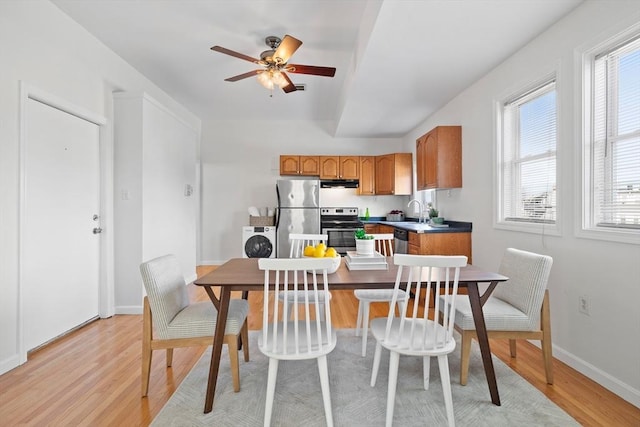 kitchen with washer / clothes dryer, sink, light hardwood / wood-style flooring, and appliances with stainless steel finishes