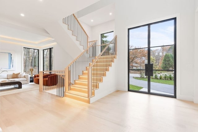 stairs with plenty of natural light and wood-type flooring