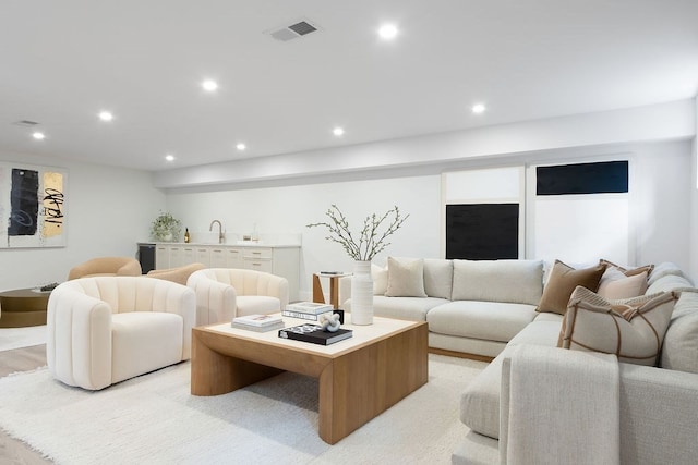 living room featuring sink and light hardwood / wood-style flooring