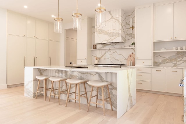 kitchen featuring white cabinetry, light hardwood / wood-style flooring, a center island, and tasteful backsplash