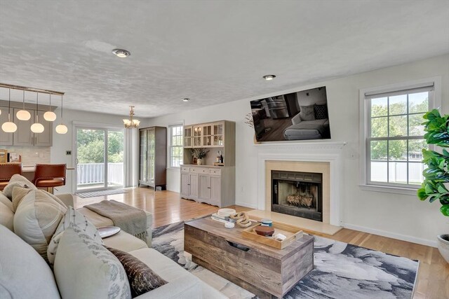 7 Sequoia Dr, Wilmington, MA 01887 - living area with healthy amount of natural light, a fireplace with raised hearth, light wood-type flooring, and a chandelier
