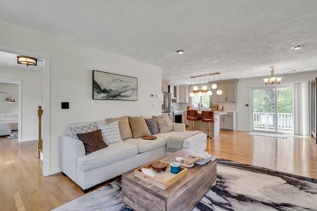 7 Sequoia Dr, Wilmington, MA 01887 - living area featuring a chandelier, light wood finished floors, and baseboards