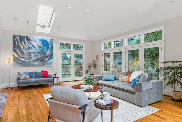 living room with baseboards, french doors, a skylight, and light wood-style floors