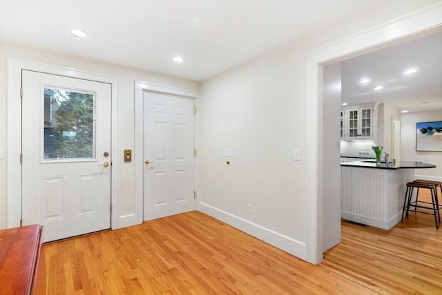 foyer entrance featuring recessed lighting, light wood-style flooring, and baseboards