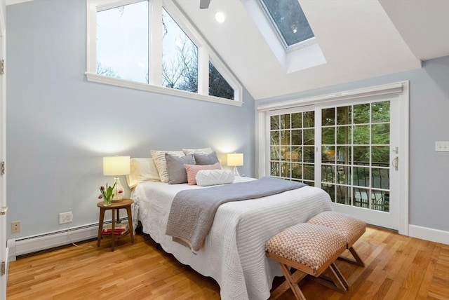 bedroom with a baseboard radiator, a skylight, light wood-style floors, high vaulted ceiling, and access to outside