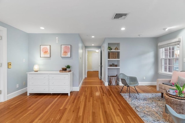 living area with light wood finished floors, visible vents, recessed lighting, and baseboards