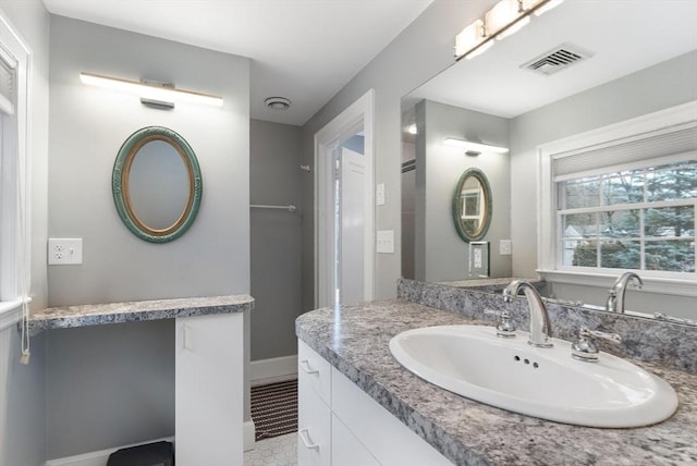 bathroom featuring visible vents, vanity, and baseboards