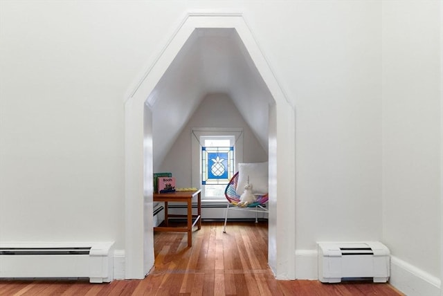 bonus room featuring a baseboard heating unit, lofted ceiling, and hardwood / wood-style flooring