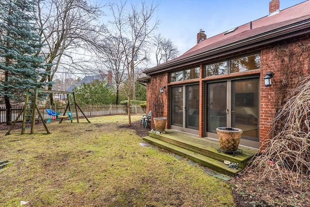 view of yard featuring entry steps, a playground, and fence