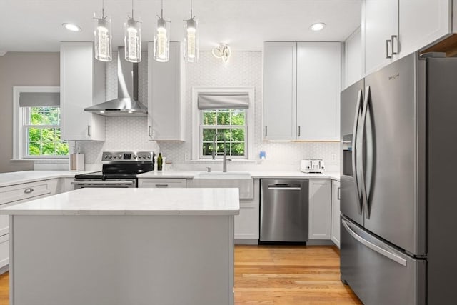 3 42nd St, Berkley, MA 02779 - kitchen with stainless steel appliances, wall chimney exhaust hood, light wood-type flooring, decorative backsplash, and a kitchen island