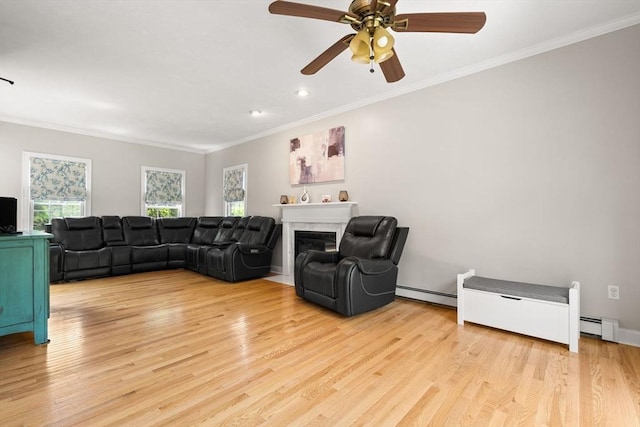 3 42nd St, Berkley, MA 02779 - living area with ornamental molding, baseboard heating, light wood-style floors, a ceiling fan, and a fireplace with flush hearth