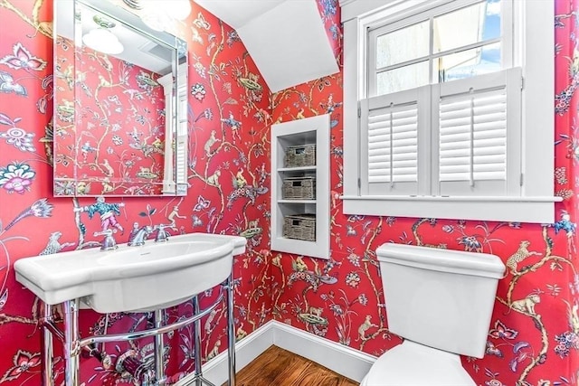 bathroom with toilet, a sink, wood finished floors, baseboards, and wallpapered walls