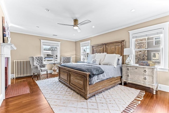 bedroom with visible vents, radiator heating unit, crown molding, light wood-style floors, and recessed lighting