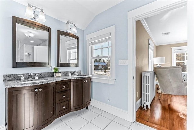 full bathroom featuring a sink, visible vents, vaulted ceiling, double vanity, and radiator heating unit