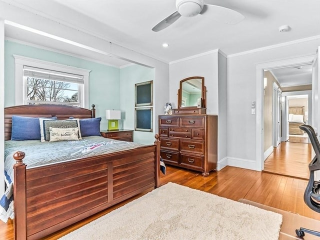 bedroom with ornamental molding, wood finished floors, a ceiling fan, and baseboards