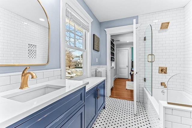 bathroom with tile patterned floors, vanity, tile walls, and wainscoting