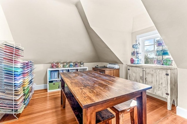 dining area featuring lofted ceiling and light wood-type flooring