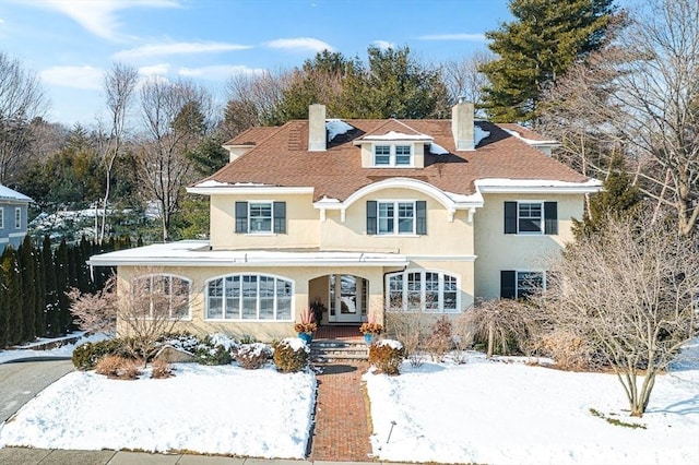 view of front of home with a chimney and stucco siding