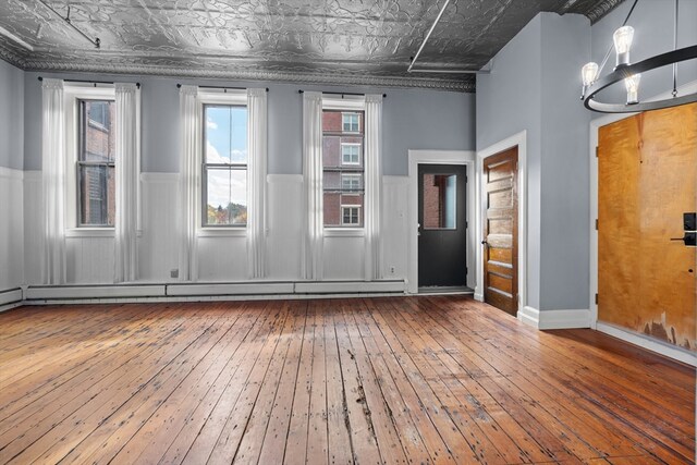 spare room featuring wood-type flooring and a chandelier