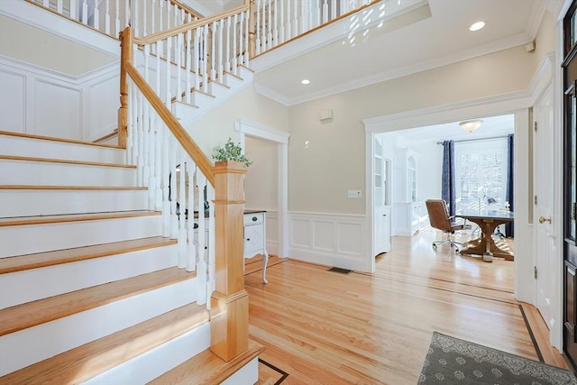 stairway featuring crown molding and hardwood / wood-style flooring