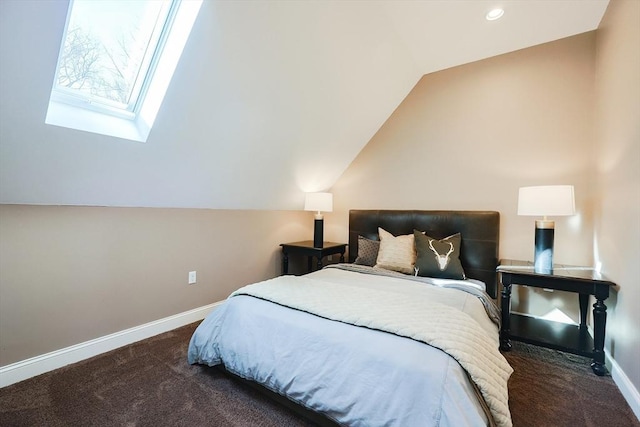 bedroom with dark carpet and vaulted ceiling with skylight